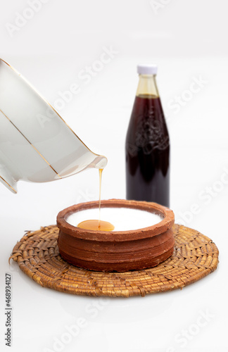 Kithul Jaggary (Caryota urens) on a clay pot of Curd topped with Kithul  treacle photo