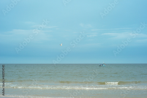 Traditional wooden boat floating in the sea for fishing with the horizontal line in background