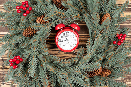 Christmas wreath and red alarm close up. Greeting card. Christmas background with alarm, concept of a Christmas shopping or busy