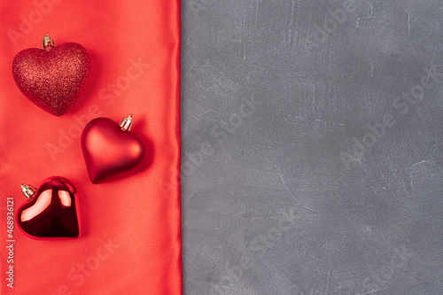 Valentines day flat lay copy space. On a gray background and a red bow, red ball hearts,