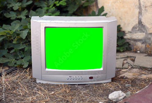 An old silvery green-screen TV for adding video sits in an abandoned hotel. Vintage TVs 1980s 1990s 2000s. 