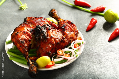 Homemade traditional Indian tandoori chicken  served in plate with fresh salads.  photo