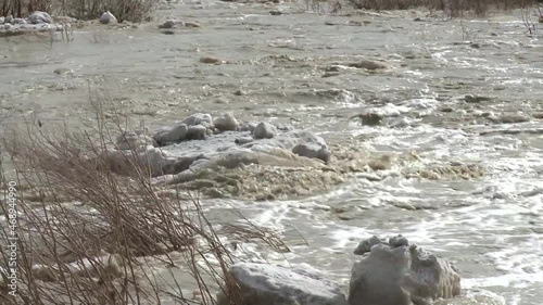 Rushing water carries ice blocks along the river.