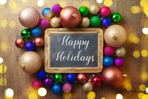 Happy Holidays greeting background with trendy modern balls ornament. Top view with copy space