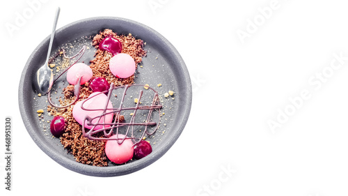 A round plate with a beautiful pink disert in the shape of a heart and a chocolate pattern. On an isolated background. Soft focus photo
