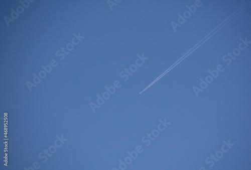 plane with chemtrails contrail, with blue sky