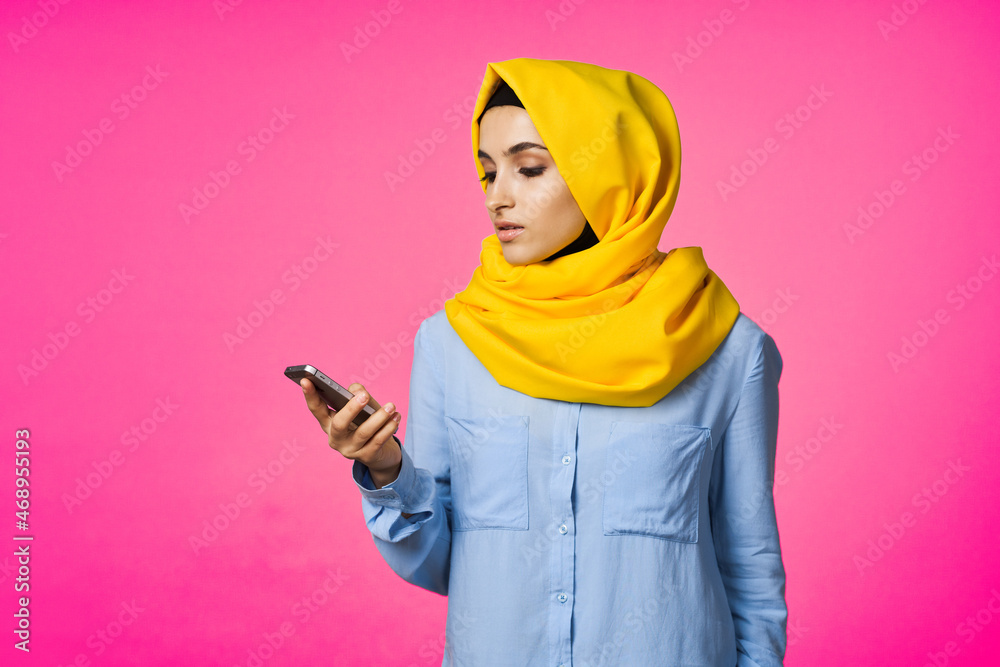 Muslim woman wearing hijab telephone communication technology pink background Muslim woman wearing hijab telephone communication technology pink background