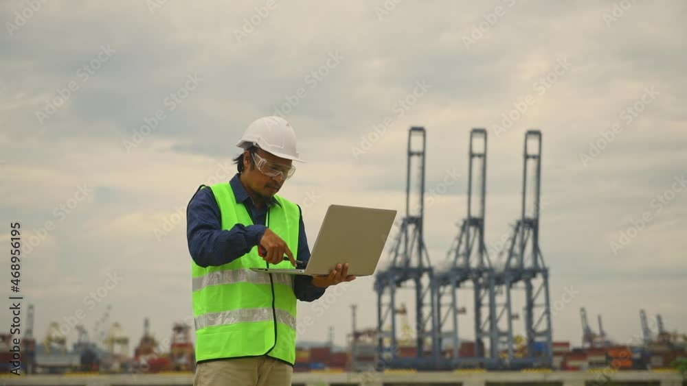 custom made wallpaper toronto digitalEngineer wearing safety uniform and helmet looking detail document on hand with logistic in habour backgroud.