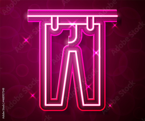 Glowing neon line Drying clothes icon isolated on red background. Clean pants. Wash clothes on a rope with clothespins. Clothing care and tidiness. Vector