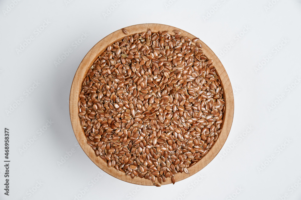 flax grain in a wooden bowl on a white background flax grain in a wooden bowl on a white background
