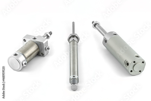 Three pneumatic air cylinders with thread and nut at the end, visible screw-in air dampers, isolated on a white background.