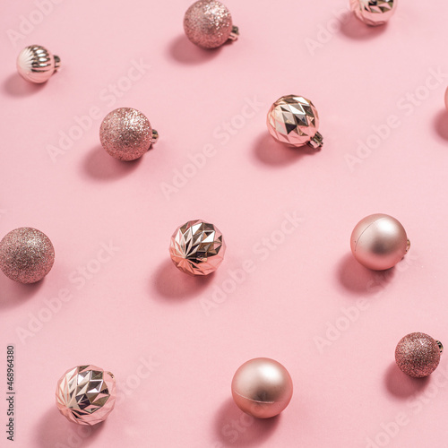 Background with beautiful shiny pink decorative balls on a pink background. Top view, flat lay.