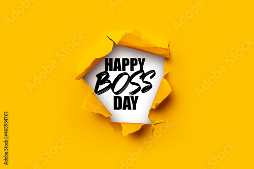 Фотография Bright yellow torn paper inside in a hole the inscription Happy boss day on a white background