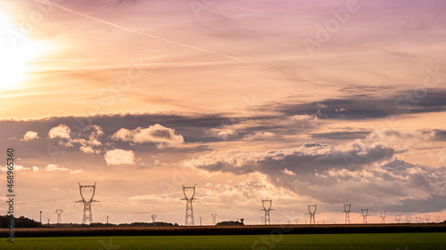 Alignement de pylônes électriques sous un magnifique coucher de soleil