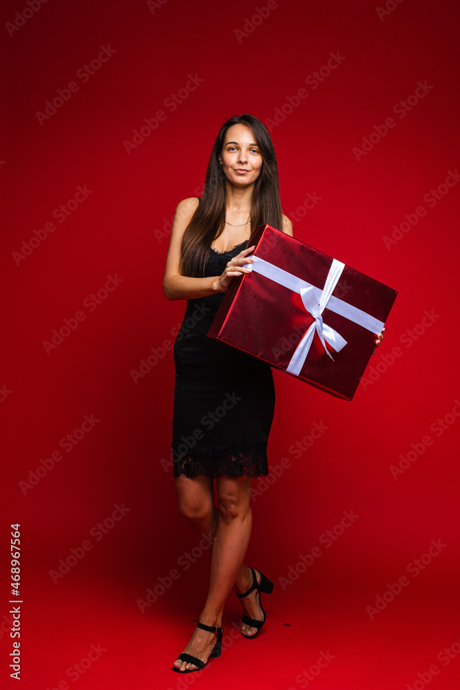 Happy brunette with red gift box posing in studio Happy brunette with red gift box posing in studio