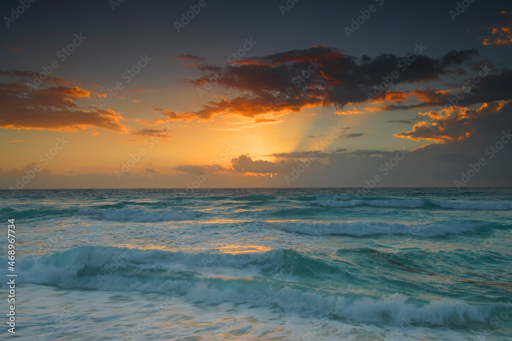 sunrise with light from behind the cloud and reflection in the ocean