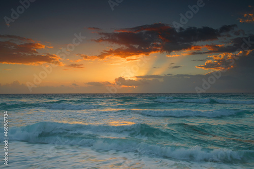 sunrise with light from behind the cloud and reflection in the ocean