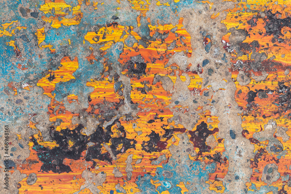 Colored concrete wall for backdrop. Remains of paint in orange, yellow, black, blue. Peeling.