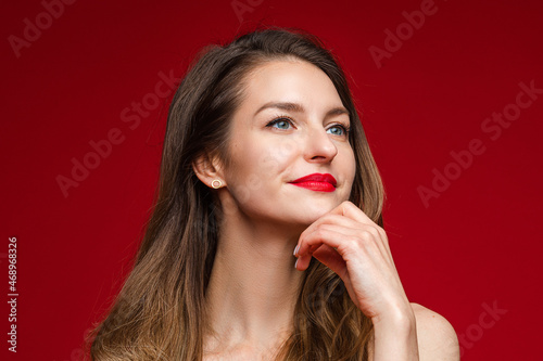 Pensive beautiful woman with hand at chin.