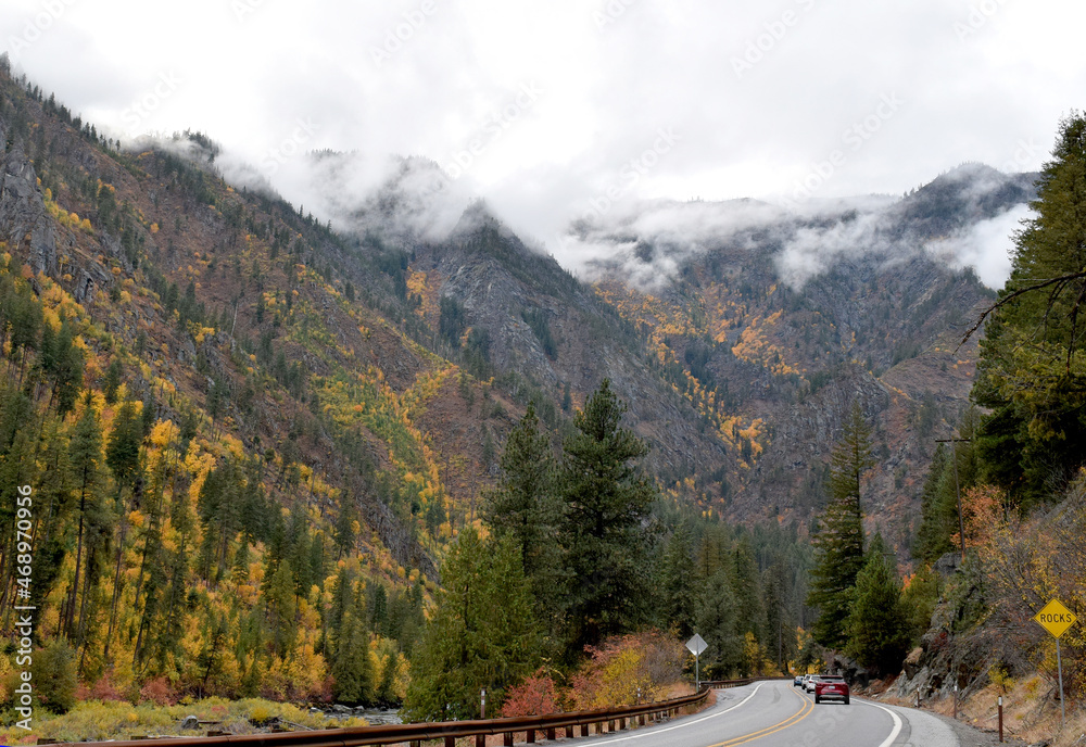 Fall colors and low stormy clouds along the Wenatchee River and highway in Washington State. 
