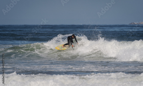 surfing the wave on the beach of La Serena Chile © oscargutzo
