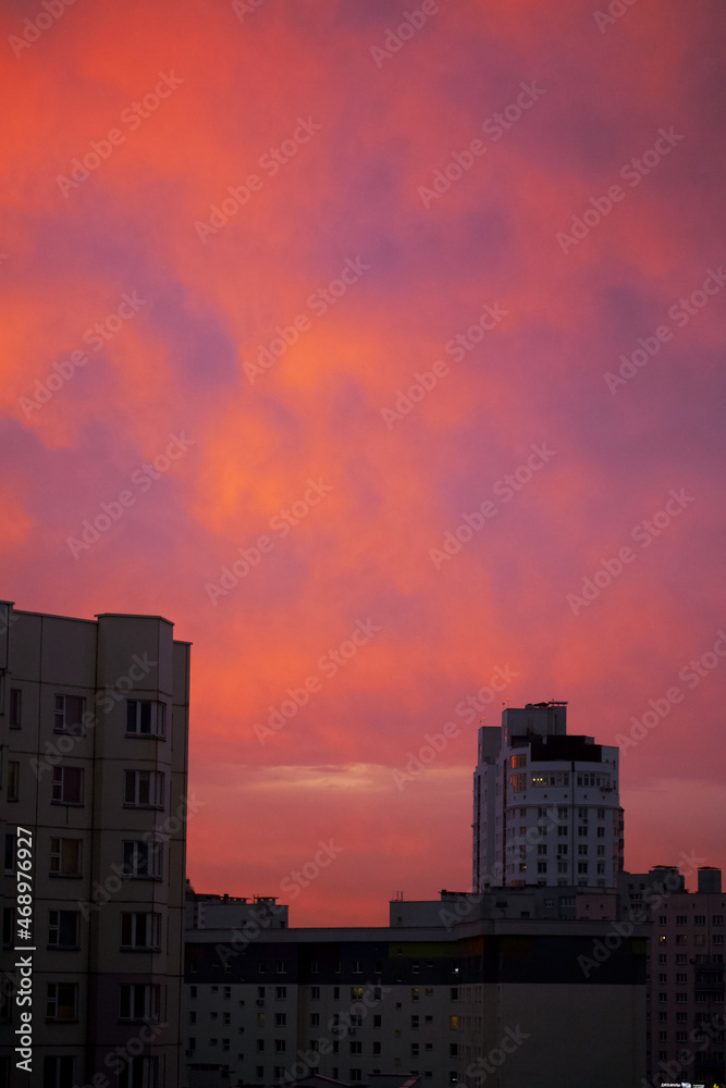 Dawn in the city. Multi-storey buildings and the sky in red and blue are visible.