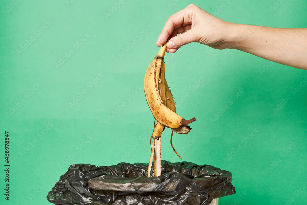 Woman throwing banana peels in trash can. Throw out banana peels in garbage. Banana skin in