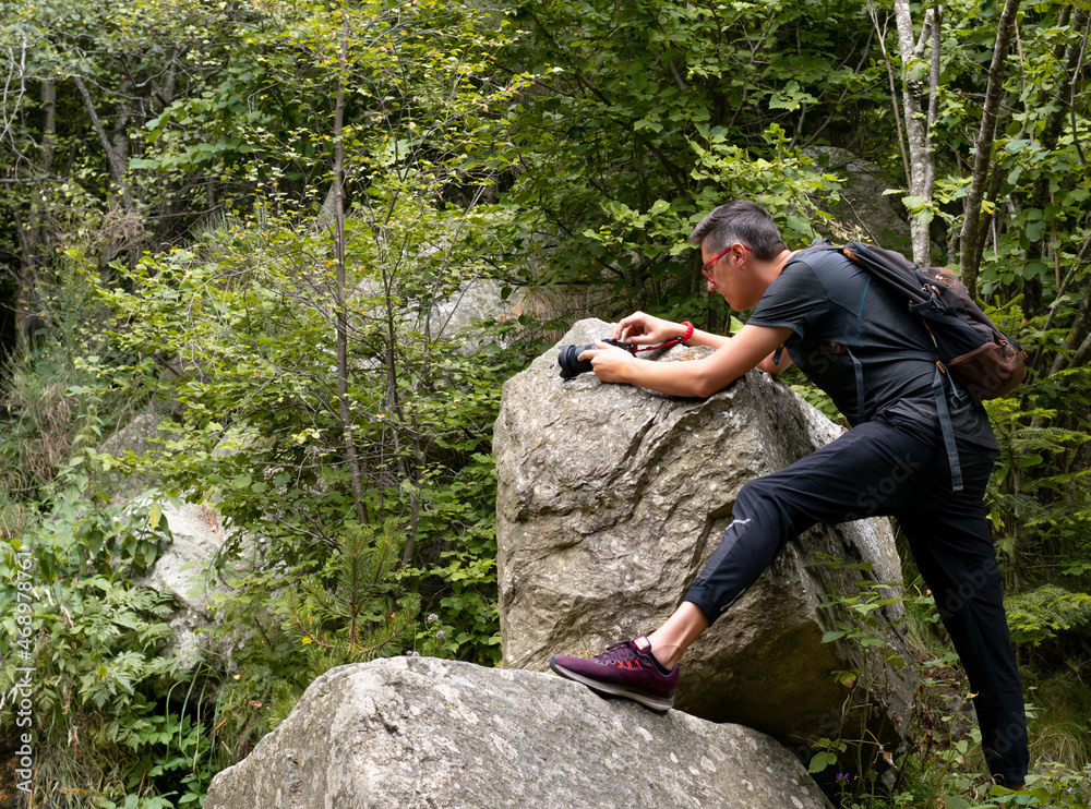 Photographer taking pictures on the mountain on a rock Photographer taking pictures on the mountain on a rock