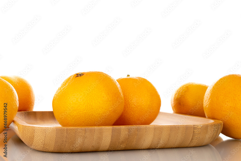 Several ripe organic tangerines in a plate made of wood, close-up, isolated on white. Several ripe organic tangerines in a plate made of wood, close-up, isolated on white.
