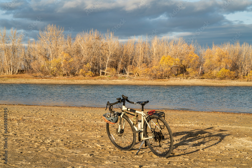 Fototapeta premium fall biking, touring or commuting - bicycle on a lake beach, Boyd Lake State Park in northern Colorado, November scenery
