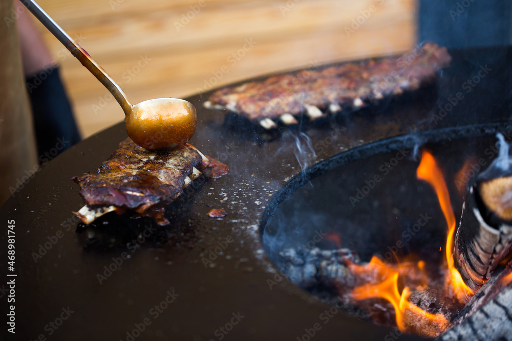 Fototapeta premium Grilled pork baby ribs with barbecue sauce on the grill. Festival street food