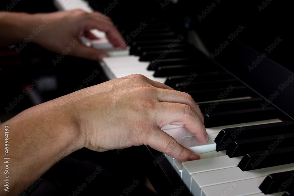 Fototapeta premium A man hands playing piano by press finger on white key for melody chord during music practice lesson. Classical music instrument.