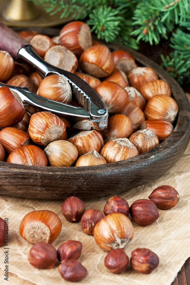 Heap of hazelnut on wooden table with nutcracker Heap of hazelnut on wooden table with nutcracker