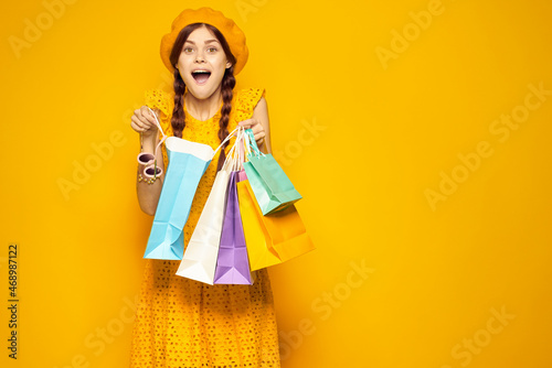 smiling woman with multicolored bags posing isolated background