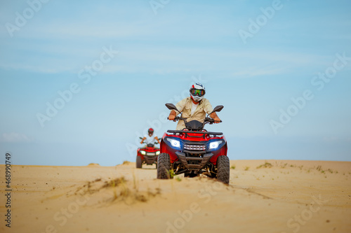 Two men in helmets ride on atv, action view © Nomad_Soul