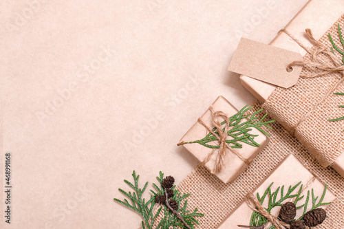 Decoration of gifts in eco-style.Gift boxes are wrapped in craft paper,tied with cotton thread,decorated with thuja leaves,cones and burlap.Christmas,New Year and eco-friendly concept,copy space.
