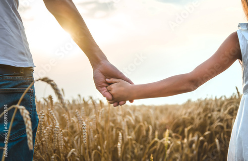 Child and father in a wheat field. Selective focus.