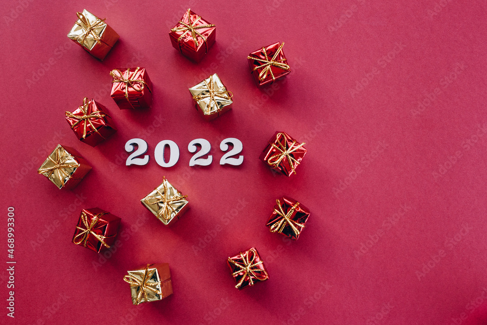 Christmas flat lay gifts and 2022 numbers on a red background Christmas flat lay gifts and 2022 numbers on a red background
