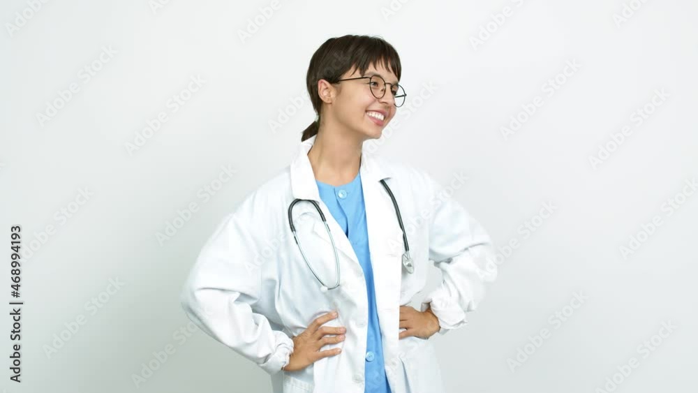 Young woman with nurse uniform posing with arms at hip and laughing over isolated background Young woman with nurse uniform posing with arms at hip and laughing over isolated background