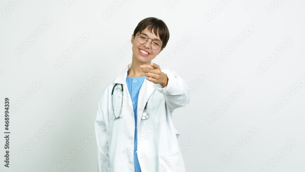 Young woman with nurse uniform points finger at you with a confident expression over isolated background Young woman with nurse uniform points finger at you with a confident expression over isolated background