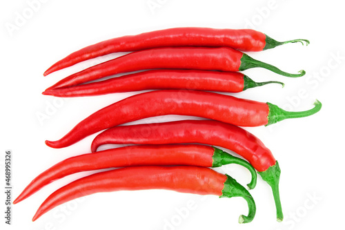 Pods of red hot chili peppers, laid out in a row on a horizontal surface