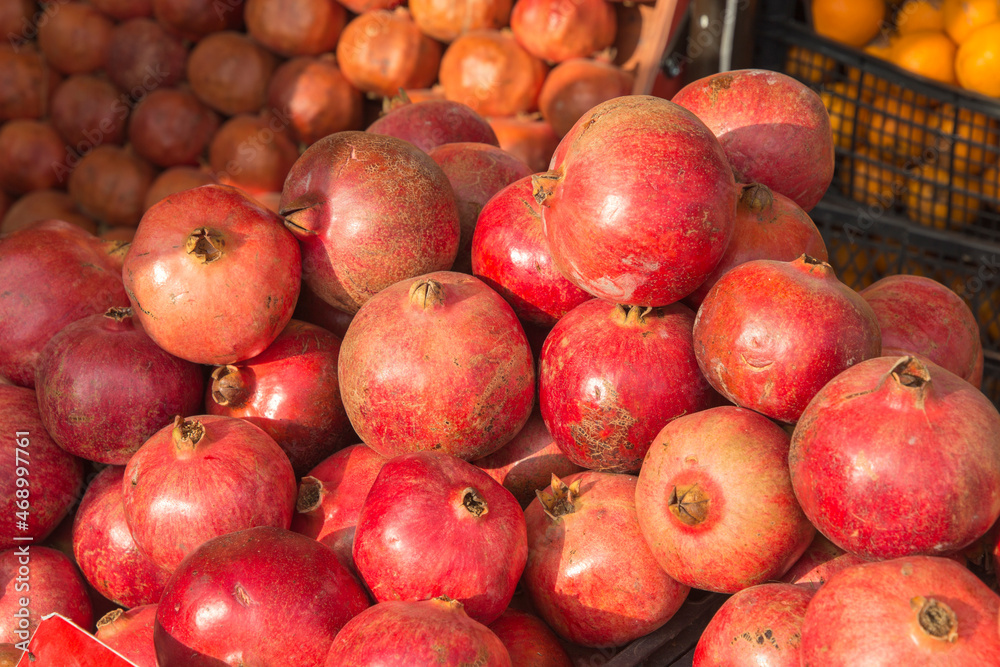 Lots of red pomegranates on the counter Lots of red pomegranates on the counter