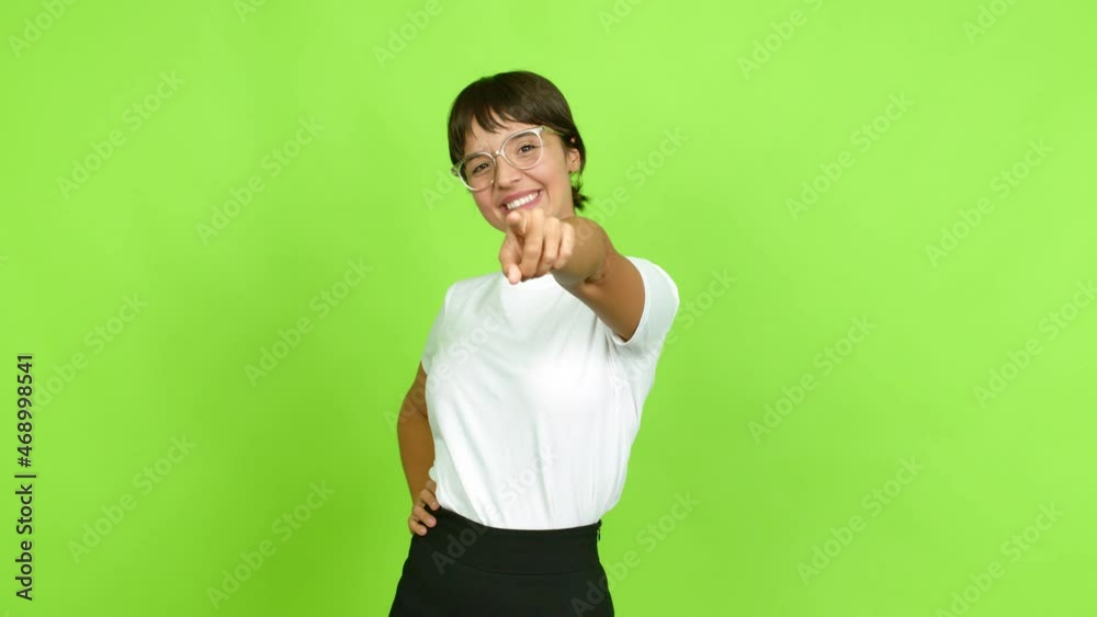 Young woman points finger at you with a confident expression over isolated background. Green screen chroma key Young woman points finger at you with a confident expression over isolated background. Green screen chroma key