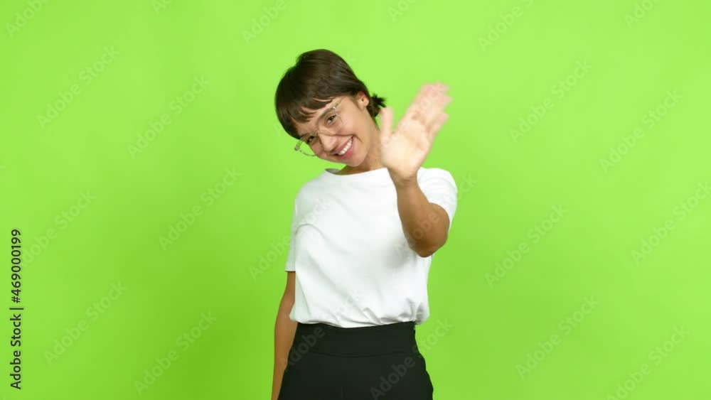 Young woman saluting with hand with happy expression over isolated background. Green screen chroma key Young woman saluting with hand with happy expression over isolated background. Green screen chroma key