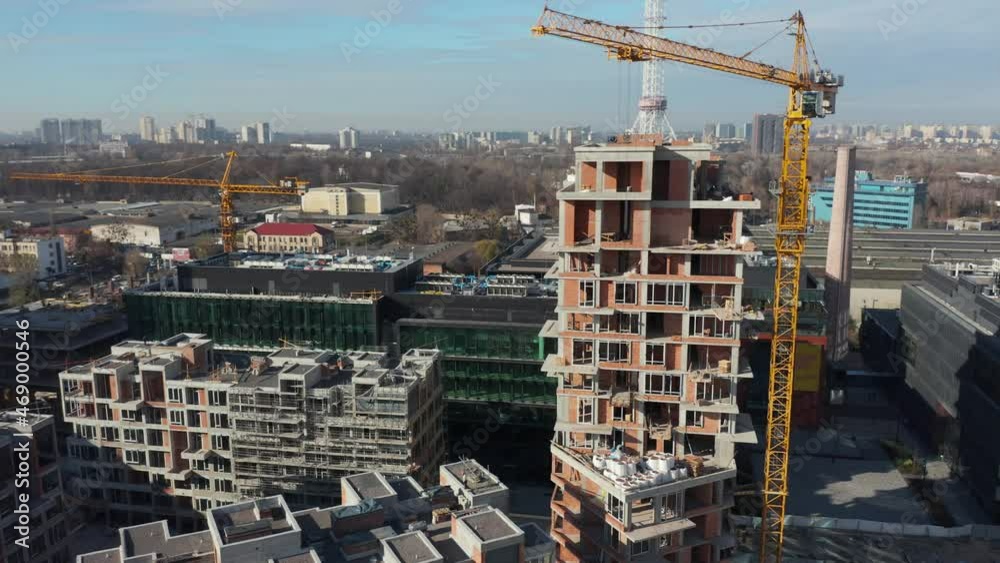 High crane works on building site with a house. Urban Construction Site, Aerial View. Construction area, building area, site area from above. New appartments getting built High crane works on building site with a house. Urban Construction Site, Aerial View. Construction area, building area, site area from above. New appartments getting built