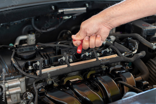 man checking car oil level. preventive vehicle maintenance