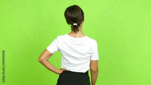 Young woman on back position looking back while scratching head over isolated background. Green screen chroma key