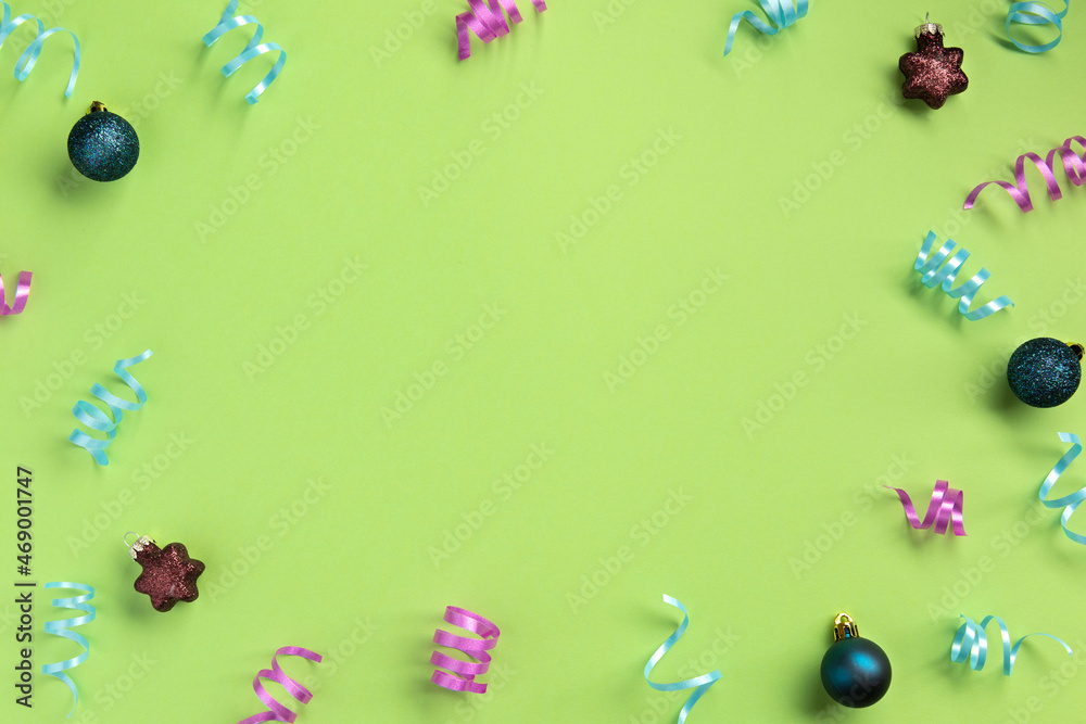 Christmas, New Year, winter concept. Colorful serpentine and balls, on green  background. Flat lay, top view, copy space.