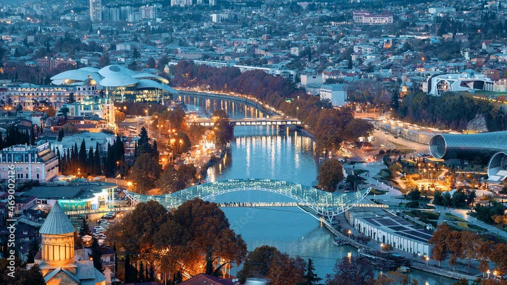 Tbilisi, Georgia. Top View Of Famous Landmarks In Night Illuminations. Georgian Capital Skyline Cityscape. City During Sunset And Night Illuminations. Day To Night Transition