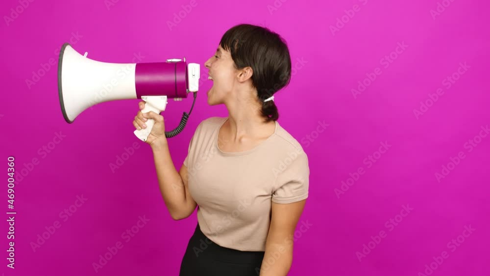 Young woman holding a megaphone and shouting over isolated background Young woman holding a megaphone and shouting over isolated background